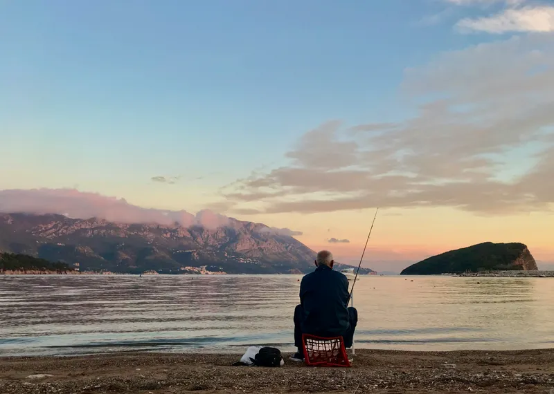A man fishing, looking at the horizon