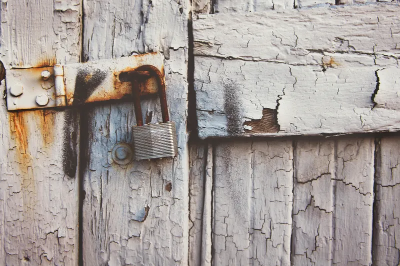 A wooden door with a padlock.