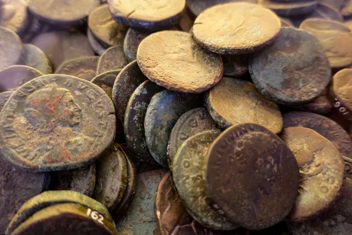 A pile of ancient Roman bronze coins covered in patina